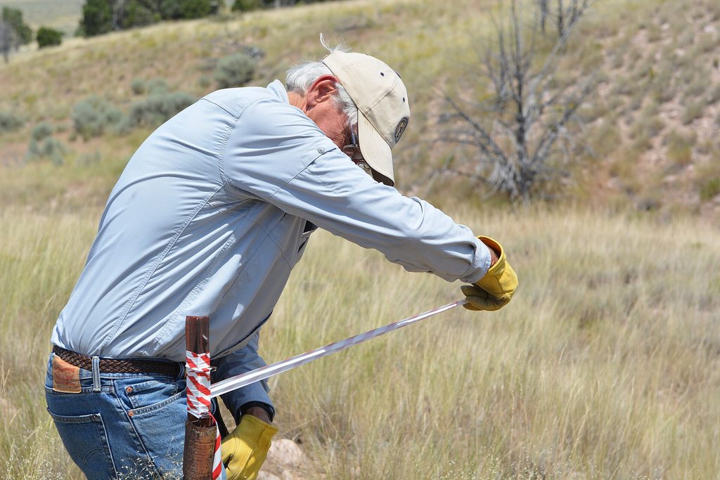 Man measuring farmland for a land tenure system